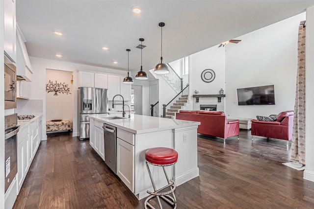kitchen featuring dark wood-style floors, open floor plan, light countertops, and appliances with stainless steel finishes