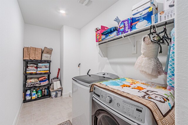 washroom featuring baseboards, washer and dryer, laundry area, and light tile patterned floors