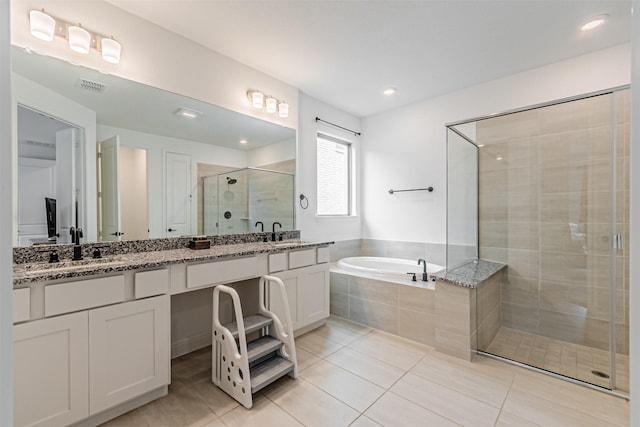 bathroom featuring a sink, a shower stall, a bath, visible vents, and double vanity