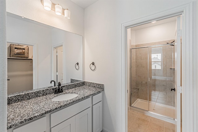 full bathroom with tile patterned flooring, vanity, and a shower stall