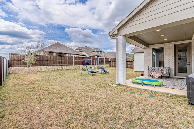 view of yard with a patio, a fenced backyard, and a playground