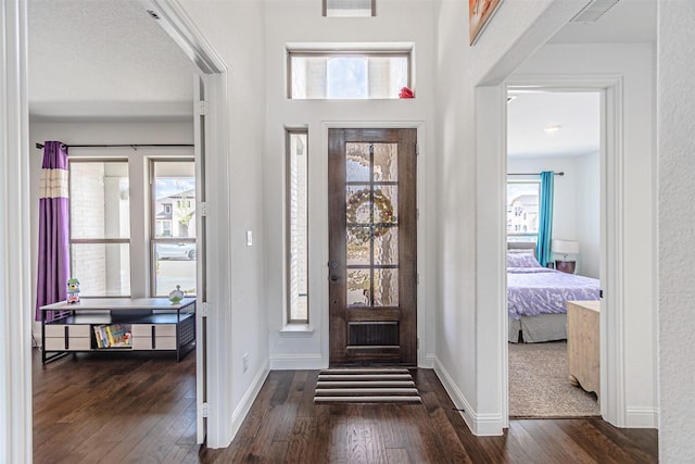 entrance foyer with baseboards, visible vents, and dark wood-style flooring