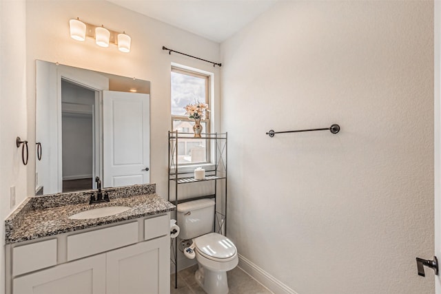half bathroom featuring baseboards, toilet, tile patterned flooring, and vanity