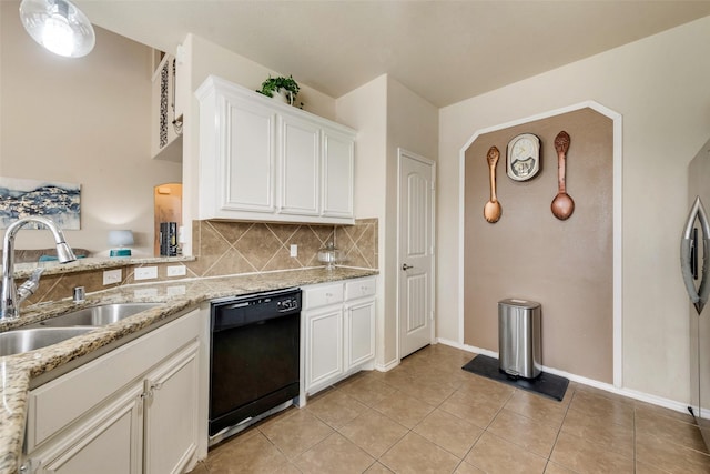 kitchen featuring tasteful backsplash, a sink, light tile patterned flooring, black dishwasher, and light stone countertops