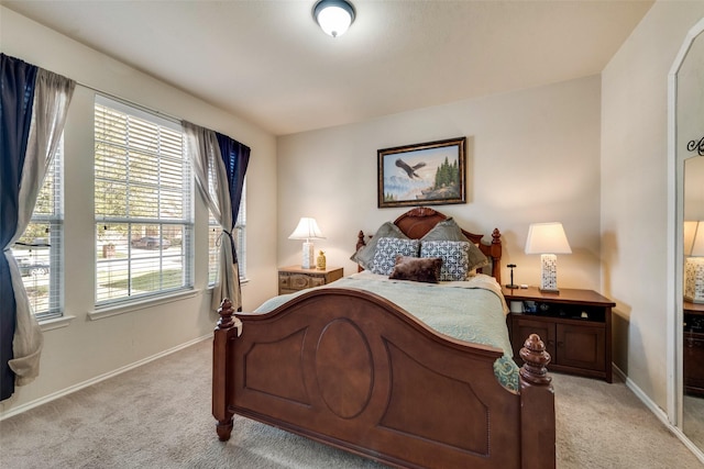 bedroom featuring light carpet and baseboards