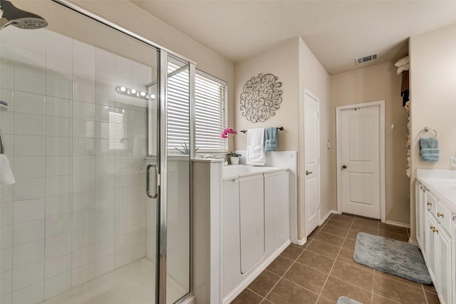 bathroom with visible vents, a stall shower, tile patterned floors, and vanity