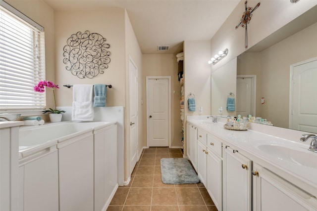 bathroom with double vanity, visible vents, tile patterned flooring, and a sink