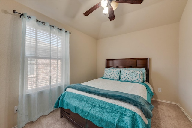 carpeted bedroom featuring baseboards, vaulted ceiling, and ceiling fan