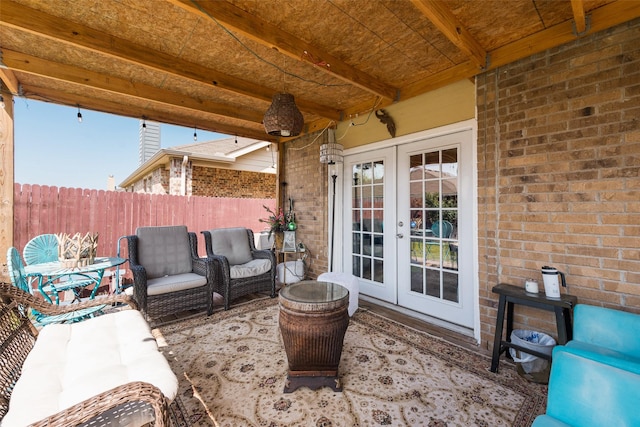 view of patio / terrace featuring an outdoor living space, fence, and french doors