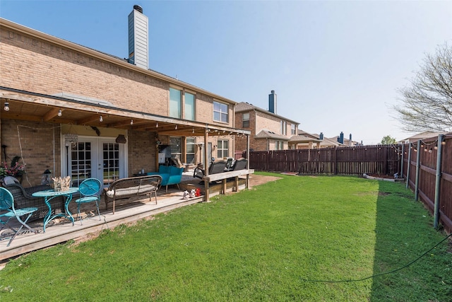 view of yard with french doors, a fenced backyard, and a patio area