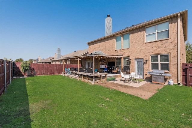 rear view of house featuring a patio, a fenced backyard, brick siding, a yard, and a chimney