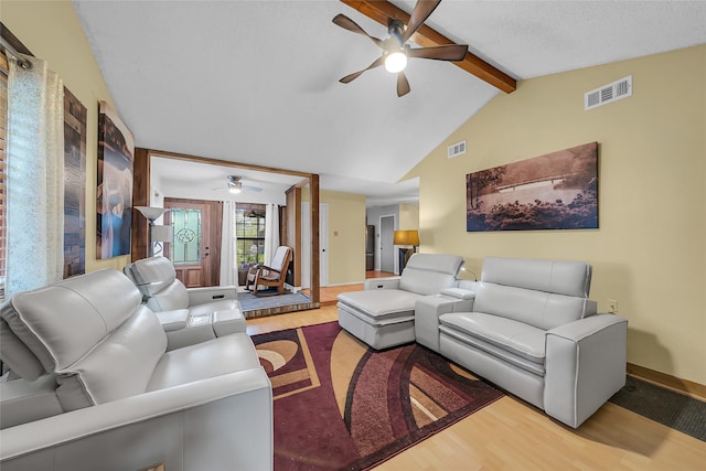living area featuring lofted ceiling with beams, visible vents, a ceiling fan, and wood finished floors