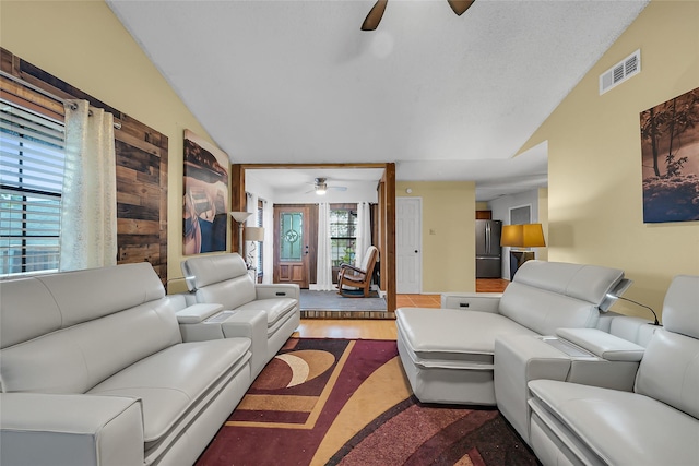 living room with wood finished floors, visible vents, lofted ceiling, and ceiling fan