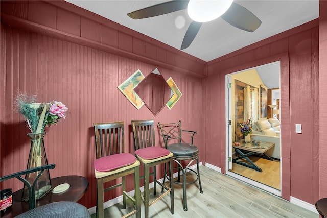 dining space with baseboards, wood finished floors, and a ceiling fan
