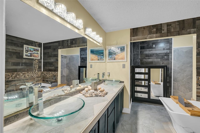 bathroom with marble finish floor, a freestanding tub, wooden walls, and a textured ceiling