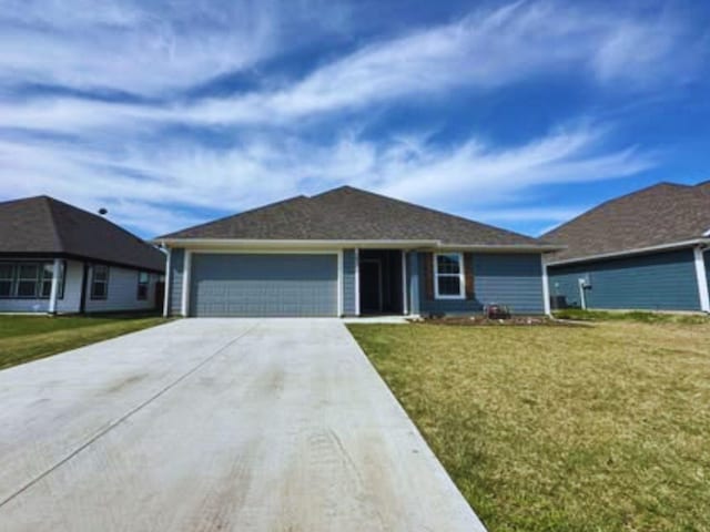 single story home with driveway, a garage, and a front lawn