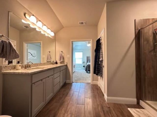 full bathroom with vanity, baseboards, a stall shower, visible vents, and wood finished floors