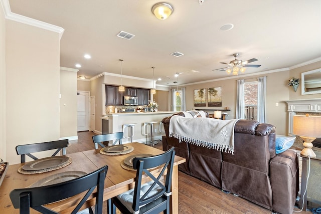dining area featuring ornamental molding, visible vents, and wood finished floors