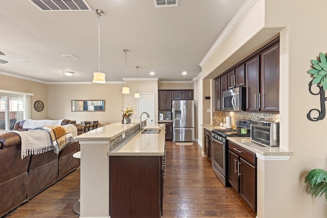 kitchen with dark brown cabinetry, a sink, open floor plan, stainless steel appliances, and visible vents