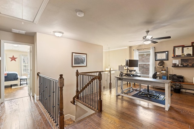 home office featuring visible vents, baseboards, a ceiling fan, attic access, and wood-type flooring