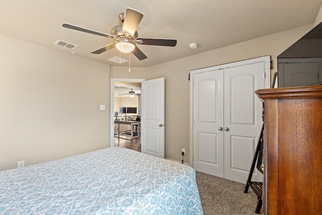 bedroom with a closet, a ceiling fan, visible vents, and carpet