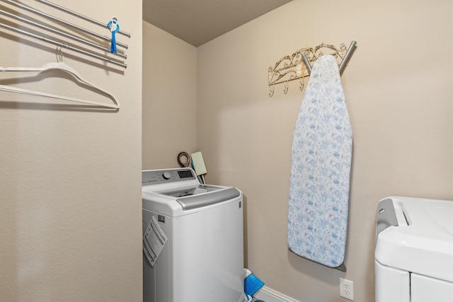 laundry room with baseboards, washing machine and dryer, and laundry area