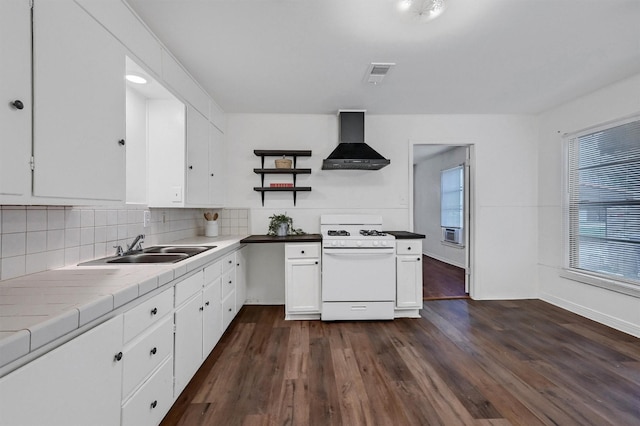 1326 W Shepherd St, Denison, TX 75020 - kitchen featuring wall chimney range hood, white range with gas stovetop, a sink, white cabinets, and tile counters