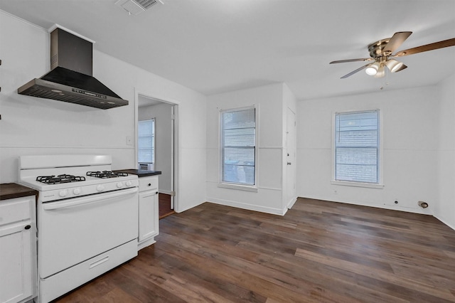 1326 W Shepherd St, Denison, TX 75020 - kitchen with white gas stove, wall chimney exhaust hood, dark countertops, dark wood-type flooring, and ceiling fan