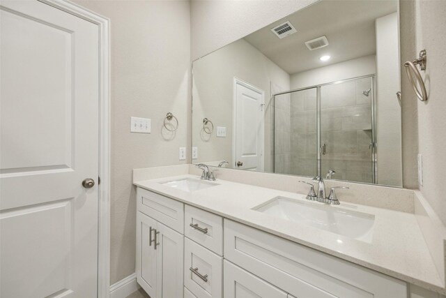 bathroom featuring visible vents, a sink, a stall shower, and double vanity