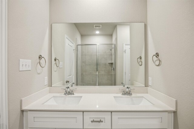 bathroom featuring a sink, a textured wall, and a stall shower
