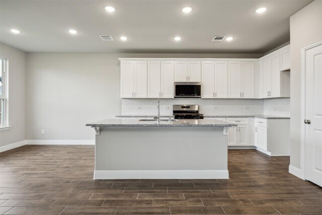 kitchen with a sink, stainless steel appliances, dark wood-type flooring, and visible vents