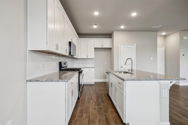 kitchen featuring stainless steel appliances, visible vents, a sink, and dark wood-type flooring