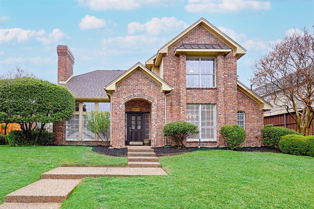2215 Burgundy Dr, Carrollton, TX 75006 - traditional-style home with roof with shingles, a front yard, fence, brick siding, and a chimney
