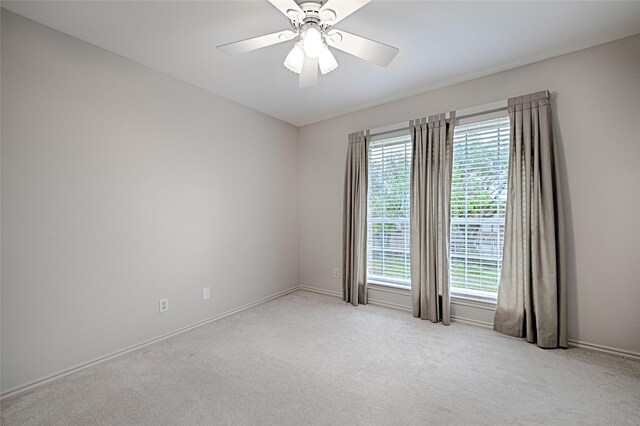 2215 Burgundy Dr, Carrollton, TX 75006 - spare room featuring light carpet, baseboards, a ceiling fan, and a healthy amount of sunlight