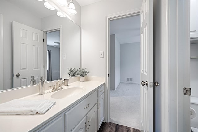 2215 Burgundy Dr, Carrollton, TX 75006 - bathroom featuring vanity, visible vents, and wood finished floors