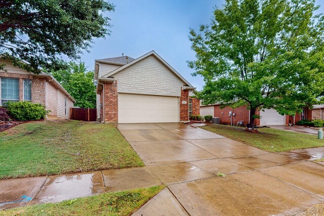 ranch-style house with a garage, central AC unit, driveway, and brick siding