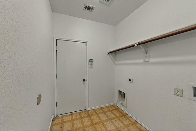 clothes washing area with hookup for an electric dryer, visible vents, light wood finished floors, and laundry area