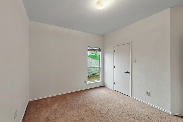 carpeted empty room featuring visible vents and baseboards