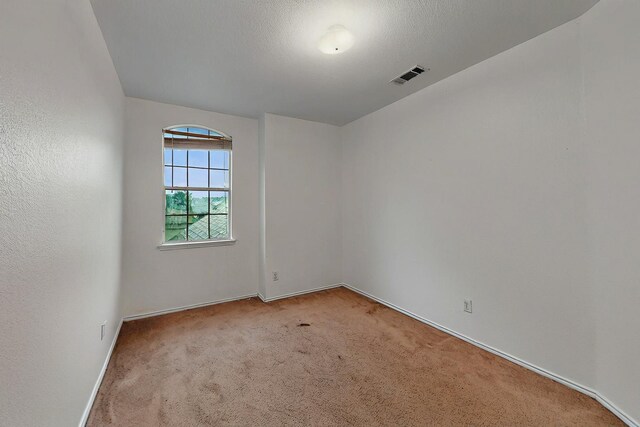 unfurnished room featuring baseboards and light carpet