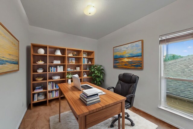 office space with baseboards and light carpet