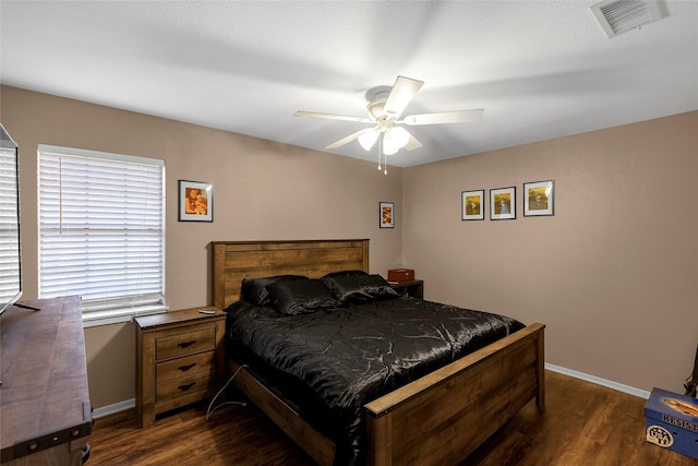 bedroom featuring a ceiling fan, dark wood finished floors, baseboards, and visible vents