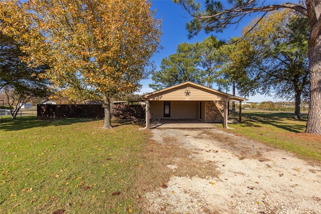 view of front of property featuring a front lawn, driveway, a carport, and fence