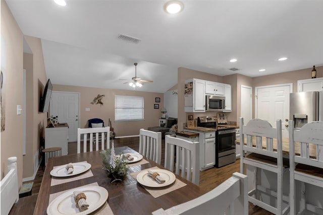dining room with ceiling fan, visible vents, vaulted ceiling, and wood finished floors