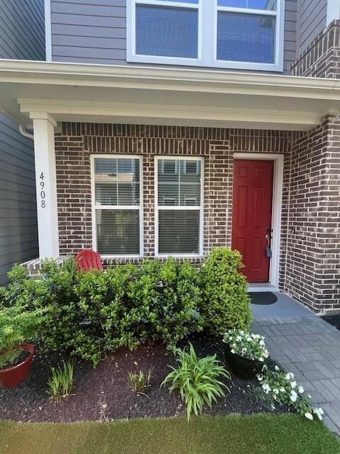 doorway to property with brick siding