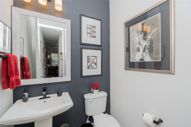 half bathroom with toilet and a sink