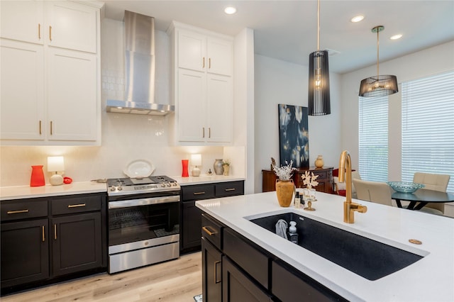 4908 Deavers Ln, Fort Worth, TX 76114 - kitchen with stainless steel gas stove, wall chimney exhaust hood, white cabinets, light countertops, and pendant lighting