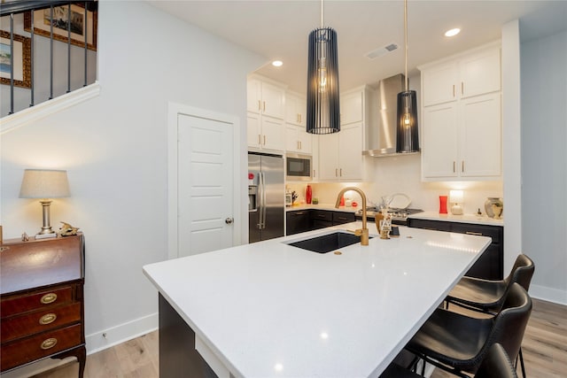 4908 Deavers Ln, Fort Worth, TX 76114 - kitchen featuring stainless steel appliances, wall chimney range hood, light wood finished floors, a sink, and baseboards