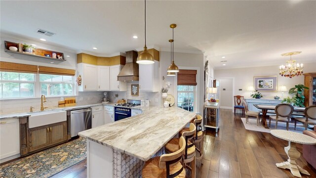133 Creek Rdg, Waco, TX 76708 - kitchen featuring stainless steel dishwasher, a sink, gas range, a peninsula, and wall chimney range hood