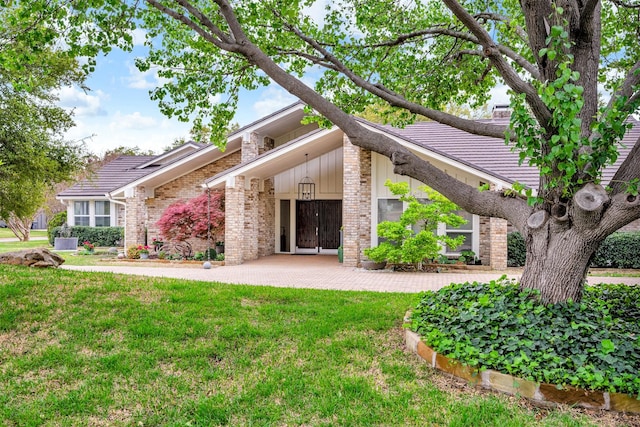 6624 Glenhurst Dr, Dallas, TX 75254 - view of front facade with a front yard, brick siding, a tile roof, and a chimney