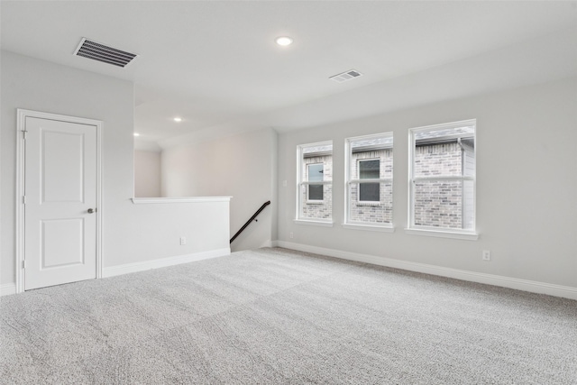 carpeted empty room featuring baseboards, recessed lighting, and visible vents